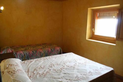 a small bedroom with a bed and a window at Ca lAntic Joanet in Mirambell