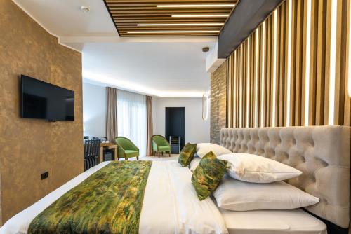 a bedroom with a large bed and a television at Hotel Ivascu in Moisei