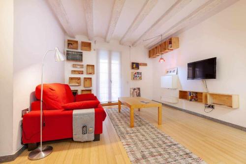 a living room with a red couch and a tv at Tarragona Circus in Tarragona