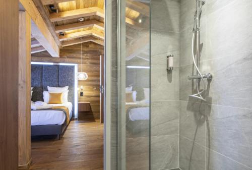 a bathroom with a shower and a bedroom with a bed at Les Balcons Platinium Val Cenis in Lanslevillard