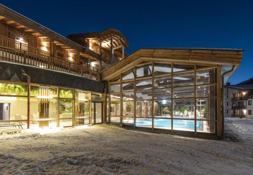 - une vue sur l'extérieur d'un bâtiment avec piscine dans l'établissement Les Balcons Platinium Val Cenis, à Lanslevillard