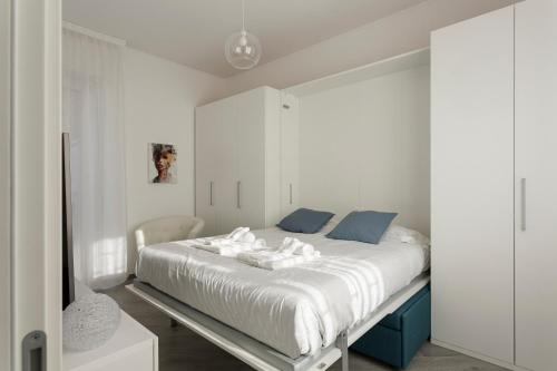 a bedroom with a large white bed with blue accents at Amazing terrace in Milan- Città Studi in Milan