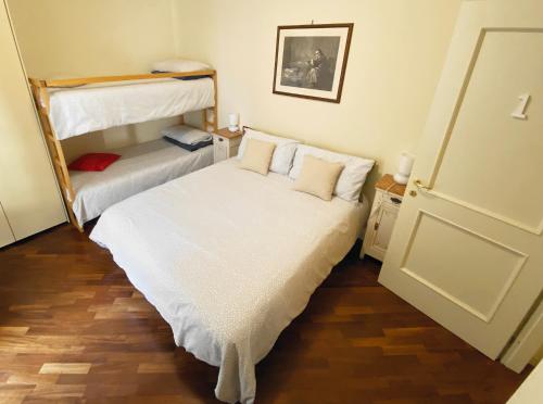 a bedroom with two bunk beds and wooden floors at La Casa di Amici Miei in Cremona