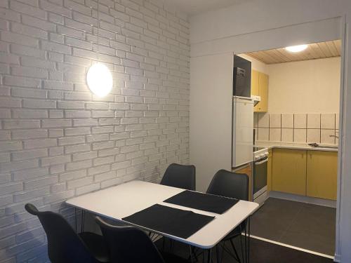 a kitchen with a table and chairs and a white brick wall at (048) Vesterhavsgade 47 door 2 in Esbjerg