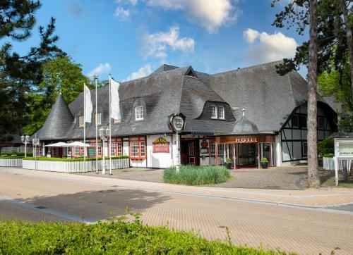 a building with a gambrel roof on a street at Landhaus Carstens in Timmendorfer Strand