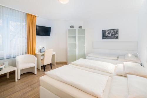 a hotel room with two beds and a desk at Stadt-gut-Hotel Rheinischer Hof in Essen