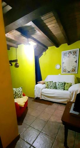 a living room with a white couch and yellow walls at La Dueña I in Miranda del Castañar