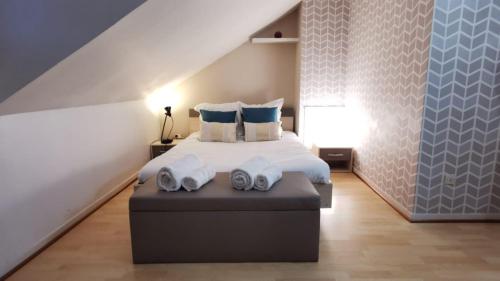 - une chambre avec un lit et 2 serviettes dans l'établissement LE DUPLEX - Hyper centre - Gare - Wifi - Netflix - Disney +, à Annecy