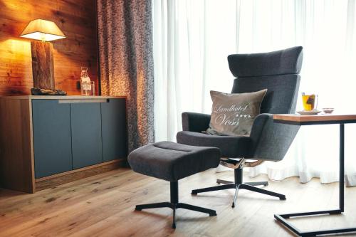a chair and a desk in a room at Landhotel Voss im TalVital in Saalhausen