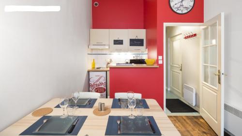 une salle à manger avec une table et un mur rouge dans l'établissement Le Kervegan, à Nantes
