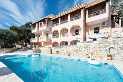 un hotel con piscina di fronte a un edificio di Corfu Shell Apartments a Barbati