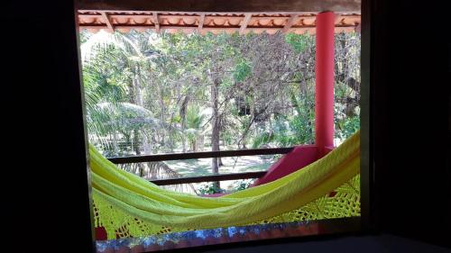 a window with a hammock on a balcony at Axé Mainha Flats! Quarta Praia! in Morro de São Paulo