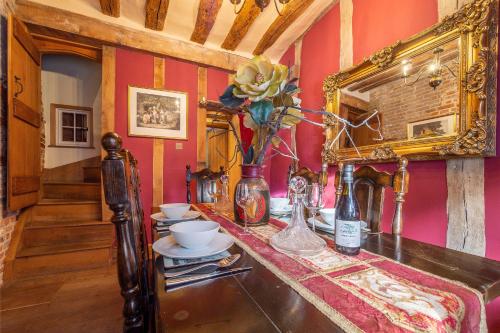 a room with a table with a vase of flowers at Extraordinary 15th Century timber framed cottage in famous Medieval village - The Tryst in Lavenham