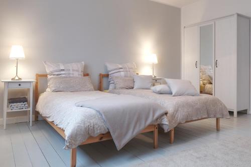 1 dormitorio blanco con 2 camas y 2 lámparas en Schicke & helle Wohnung in Mülheim an der Ruhr en Mülheim an der Ruhr