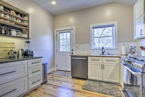 a kitchen with white cabinets and a sink at Renovated Carrboro House with Deck and Fire Pit! in Carrboro