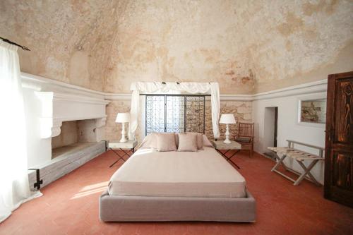 Un dormitorio con una cama grande y una ventana en Masseria Francescani en Torre Chianca