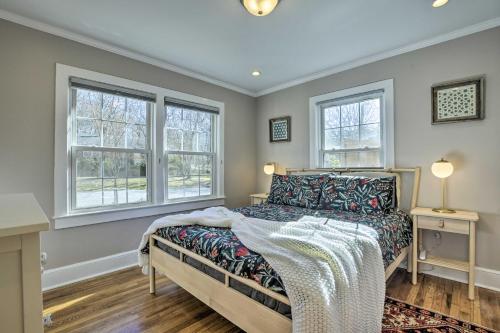 1 dormitorio con 1 cama y 2 ventanas en Renovated Carrboro House with Deck and Fire Pit!, en Carrboro