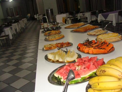 a long table with many plates of food on it at Hotel Itamaraty in Curitiba