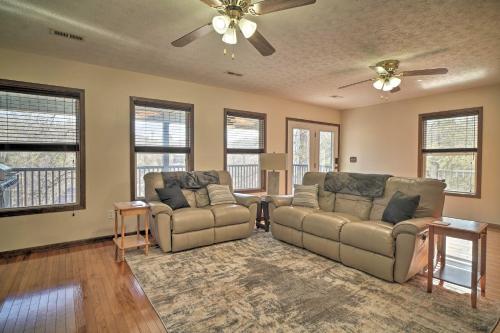 a living room with two couches and a ceiling fan at Caryville Home with Dock, Steps to Norris Lake! in Caryville