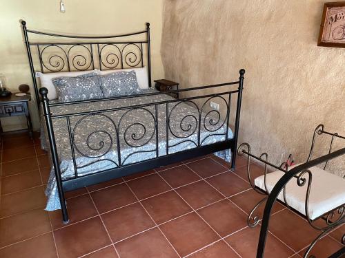ein schwarzes Bett in einem Zimmer mit Stuhl in der Unterkunft El Rinconcito in Fuentespalda