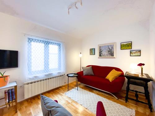 a living room with a red couch and a tv at Apartment Mletačka in Zagreb