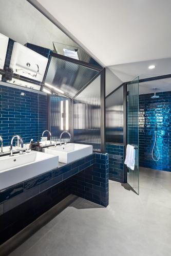 a bathroom with two sinks and blue tiles at chic&basic Gravity in Porto