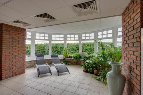 a patio with chairs and plants in a building at Home Farm B&B - Sunflower Room in Forfar