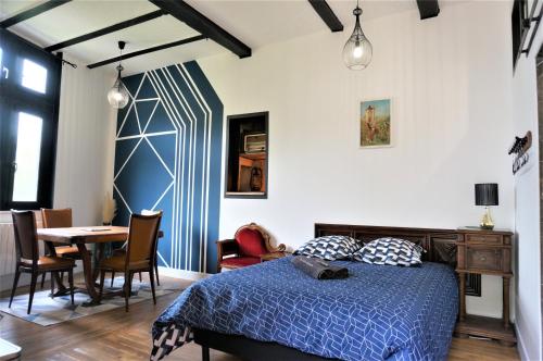 um quarto com uma cama, uma mesa e cadeiras em gîte du tourneur studio au cœur de saint cirq em Saint-Cirq-Lapopie