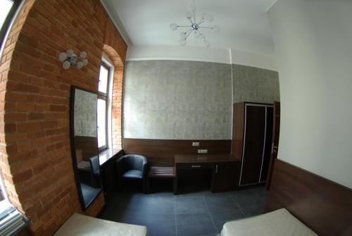a room with a desk and chairs and a brick wall at Aparthotel Łódź 55 Piotrkowska in Łódź