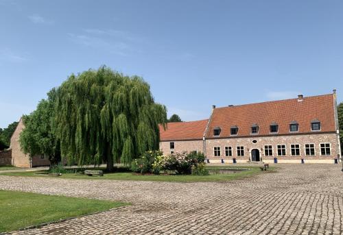 a large brick building with a tree in front of it at CHAPEAUVEAU Gîte - b&b - Events in Helecine