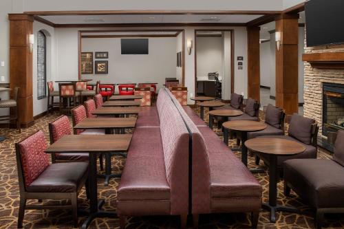 a restaurant with tables and chairs and a fireplace at Staybridge Suites North Charleston by IHG in Charleston