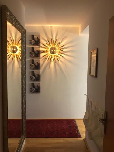 a hallway with two lights on a wall with a mirror at Enzian 14 - Schmuckstück von Bad Kleinkirchheim in Bad Kleinkirchheim