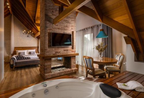 a living room with a tub and a fireplace at Hotel Valle Dincanto in Gramado
