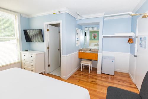a bedroom with a bed and a bathroom with a sink at Island House Hotel in Mackinac Island