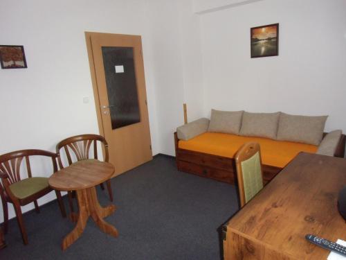 a small room with a bed and a table and chairs at Penzion Pod Zámkem in Zruč nad Sázavou