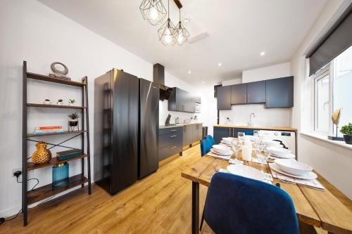 a kitchen and dining room with a table and chairs at 7 bedroom house ENSUITE Rooms, fully equipped kitchen, free WIFI, TVs in all rooms CITY CENTRE CLOSE TO A46 Inspire Homes in Coventry