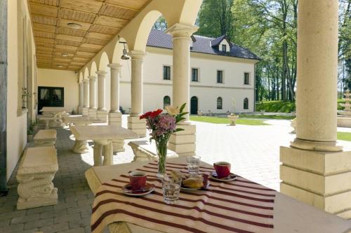 a table with a vase of flowers on a patio at Zámek Kamenný Dvůr in Kynšperk nad Ohří