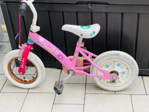 a pink bike with white wheels sitting on a floor at Dundee's Point in Szentendre
