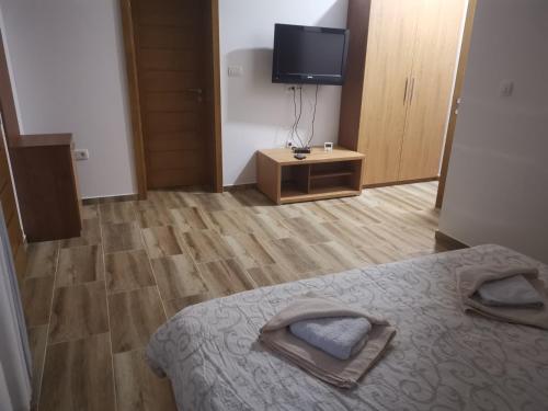 um quarto com uma cama e uma televisão de ecrã plano em Zlatarska dolina em Nova Varos