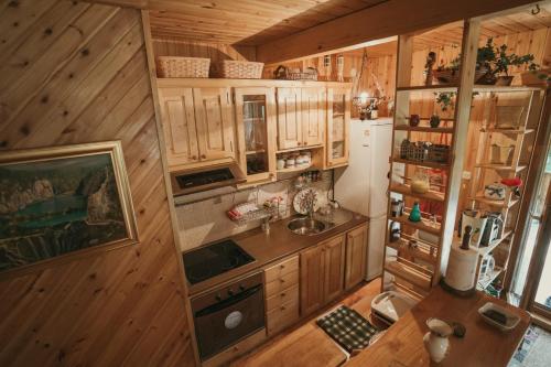 cocina con armarios de madera, fregadero y nevera en House Poljana, en Lagos de Plitvice
