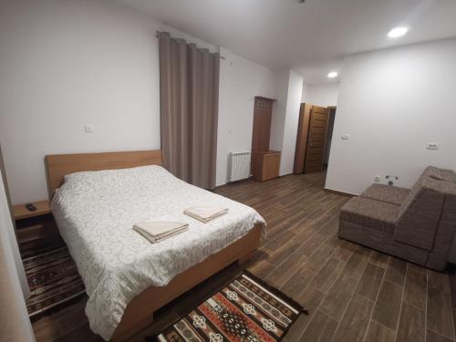 ein kleines Schlafzimmer mit einem Bett und einem Sofa in der Unterkunft Zlatarska dolina in Nova Varoš