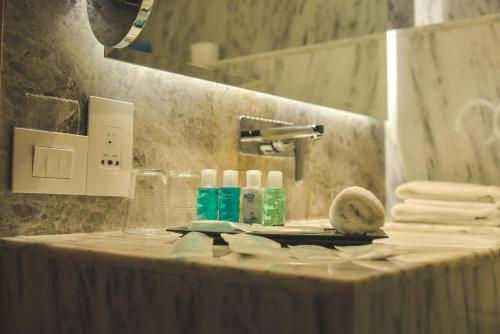 a bathroom counter with a sink with towels on it at Bravia Hotel Niamey in Niamey