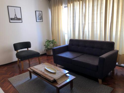 sala de estar con sofá y mesa en Departamento en Ciudad de Mendoza en Mendoza