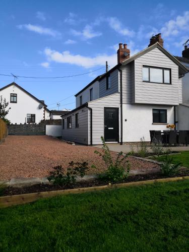 a white house with a driveway in a yard at Bowkett Cottage in Cinderford