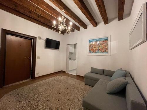 a living room with a couch and a chandelier at Ca Marga Cannaregio - Central Venetian Style 2 bedroom apartment in Venice