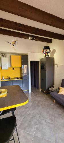 un salon avec une table et une cuisine dans l'établissement Super appartement les pieds dans l eau, au Cap d'Agde