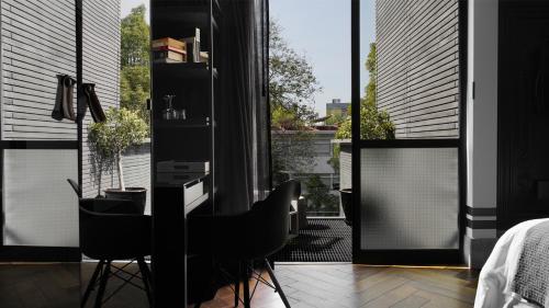a bedroom with a desk and chairs in front of a window at The Wild Oscar in Mexico City