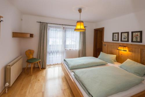 sypialnia z dwoma łóżkami i oknem w obiekcie Forsthaus Pernthaner w Saalbach Hinterglemm