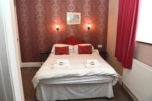 a bedroom with a large bed with red walls at Brynhyfryd Guest House in Cardigan