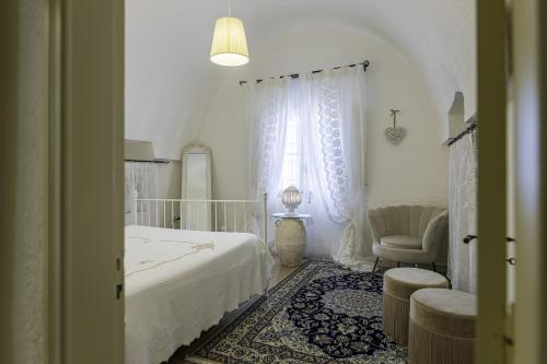ein Schlafzimmer mit einem Bett, einem Stuhl und einem Fenster in der Unterkunft Andrew'S home - Luisanna in Torre Pali 
